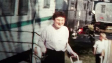 Woman and Man Leaving a Trailer at Home Park