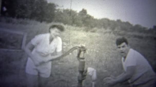 A woman pumping the well while a man washes — Stock Video