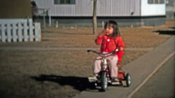 Hermana mayor liderando el camino con su hermano pequeño en las aceras con triciclos — Vídeo de stock