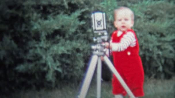Bebé hilarante trabajando la cámara en un trípode — Vídeo de stock