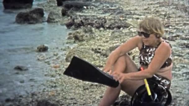 Kobieta wkładająca sprzęt do nurkowania i pływająca w falach — Wideo stockowe