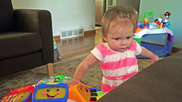Bebé de pie cerca de juguetes — Vídeo de stock