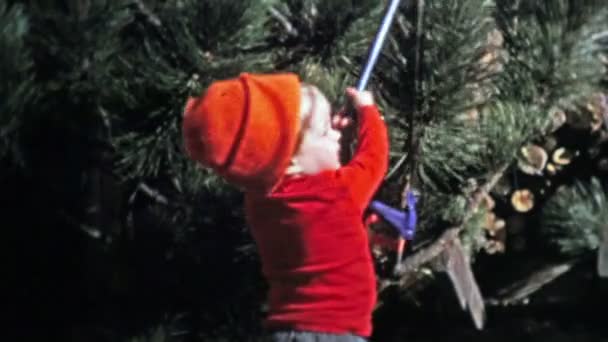 Bébé tenant une scie à arbre de Noël pour imiter papa — Video