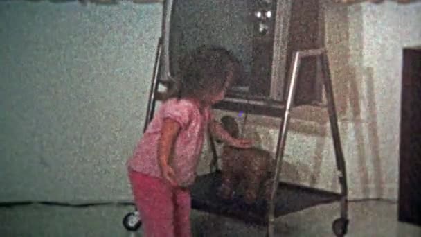 Girl putting coins in piggy bank under the vintage tv — Stock Video