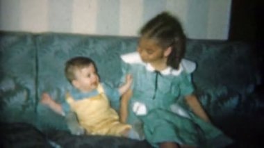 Kız ve erkek kardeş bebekle poz