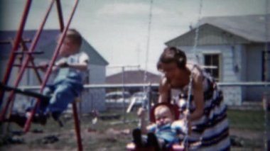 Anne çocuklarla swingset üzerinde çalış.