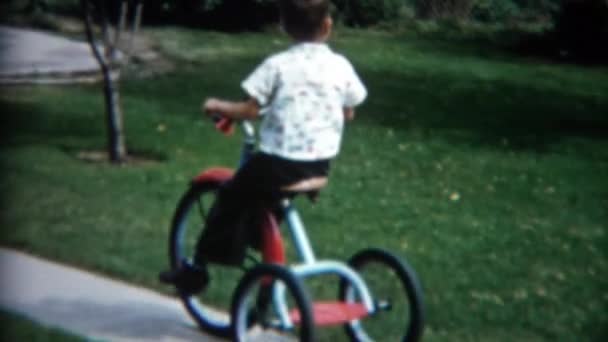 Garçon sur tricycle à la maison cour avant trottoir — Video