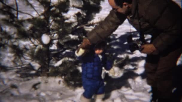 Chica joven en la nieve y papá ayudando — Vídeos de Stock
