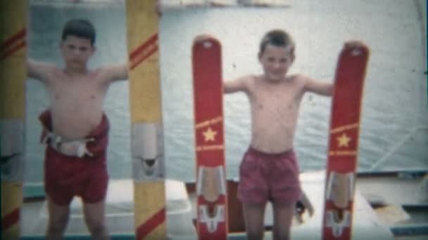 Kids holding water skis on the side of the lake — Stock Video