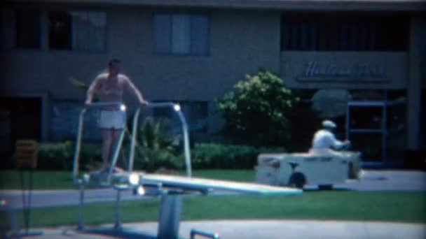 Hombre saltando de la piscina del hotel — Vídeos de Stock