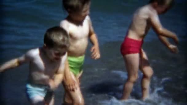 Hermanos jugando en la playa rocosa — Vídeos de Stock