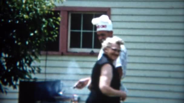Mãe dando cozinhar filho grelhando ao ar livre — Vídeo de Stock