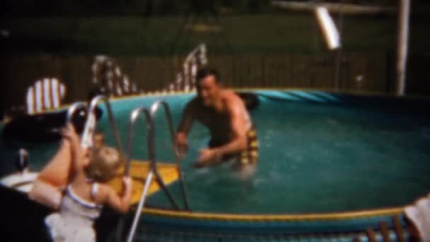 Дети прыгают в объятия отца в бассейне — стоковое видео