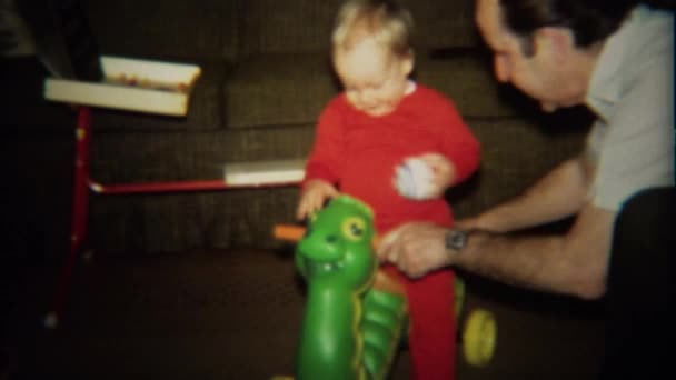 Grandpa plays with baby on turtle toy scooter — Stock Video