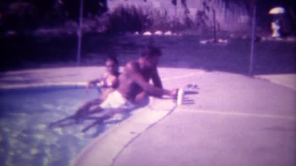 Hombre fumando en piscina con joven compañero — Vídeos de Stock