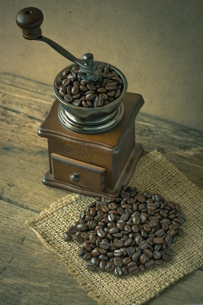 Grains de café et moulin à café sur le bois — Photo
