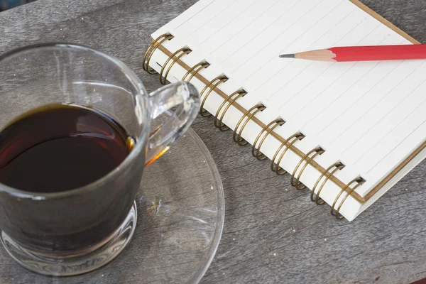 Kaffeetasse und Notizbuch auf dem Holztisch — Stockfoto