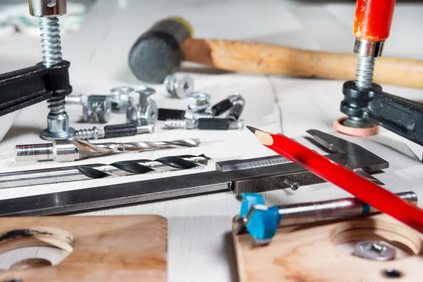 Sul tavolo ci sono strumenti per il montaggio di mobili: trapano, cacciavite, martello, maglio, morsetto, guanti — Foto Stock