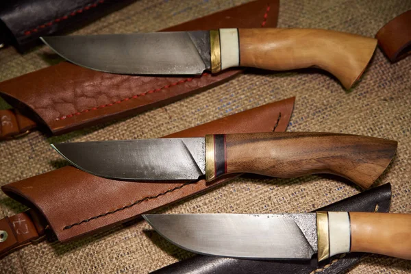 Various hunting knives with wooden handle and scabbard