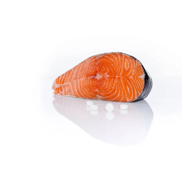 生鲑鱼牛排和白底维生素丸 — 图库照片