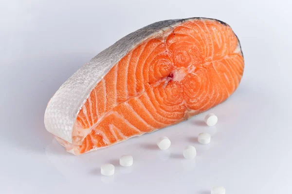 白身魚のサーモンステーキとビタミンの丸薬 — ストック写真
