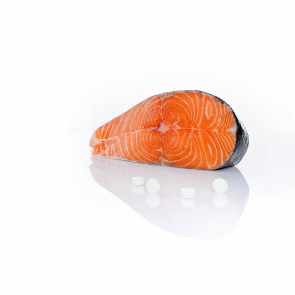 白身魚のサーモンステーキとビタミンの丸薬 — ストック写真