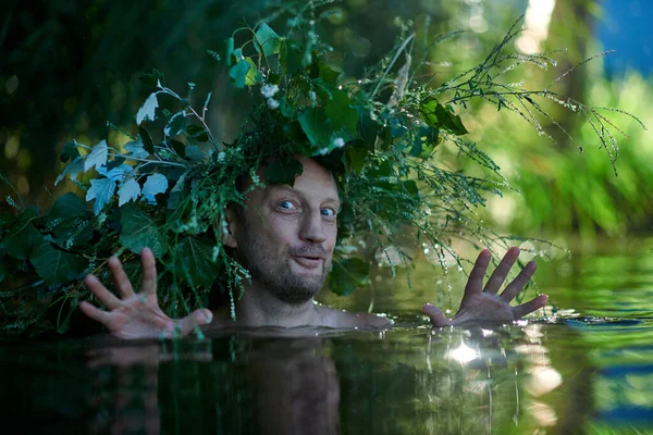 Funny fabulous man water wizard wearing a crown of grass in the lake