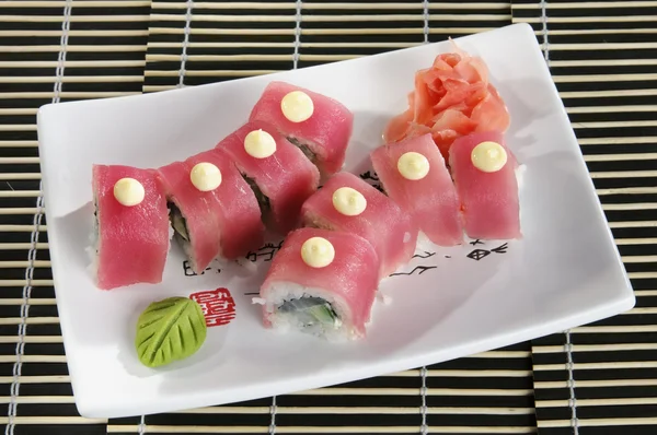 Sushi menu: a set of rolls of salmon and avocado with wasabi and ginger on a plate — Stock Image Sushi menu: a set of rolls of salmon and avocado with wasabi and ginger on a plate Royalty Free Stock Photos