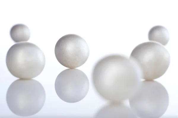 Perlas aisladas sobre mesa espejo blanco — Foto de Stock