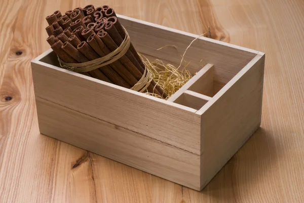A bunch of cinnamon sticks in a wooden box — Stock Photo, Image