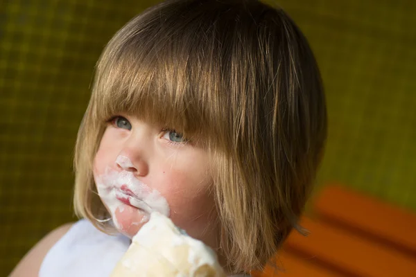 Маленькая девочка ест мороженое и немного грязно . — стоковое фото