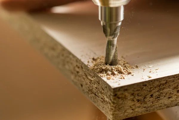 Furniture assembly. Master drills drill a hole in the furniture board. — Stock Image Furniture assembly. Master drills drill a hole in the furniture board. Stock Image