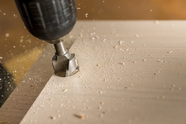 Furniture assembly. Master drills drill a hole in the furniture board. — Stock Image Furniture assembly. Master drills drill a hole in the furniture board. Stock Picture