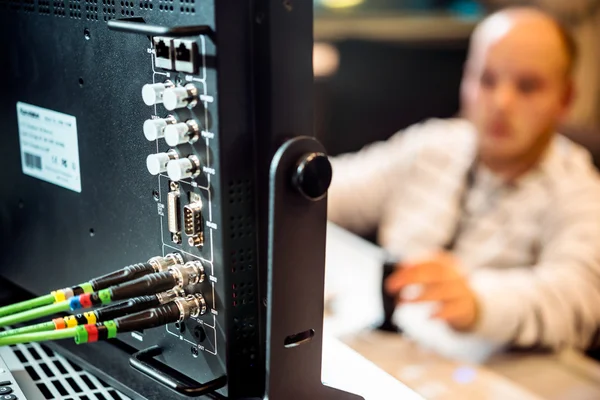 Cables de red conectados a un monitor, un programador de computadoras se sienta un hombre . — Foto de Stock