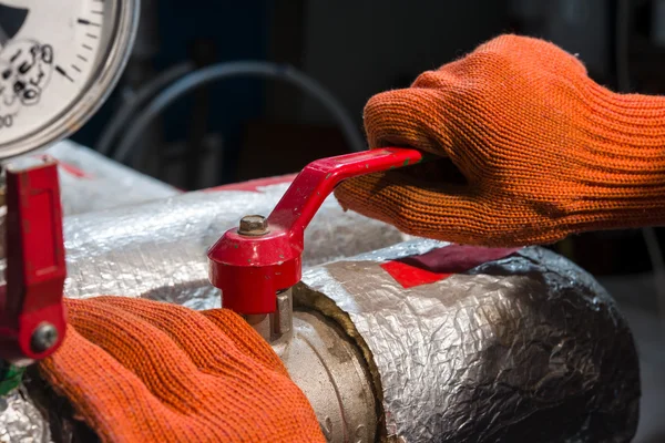 Master in working gloves red valve covers — Stock Photo, Image