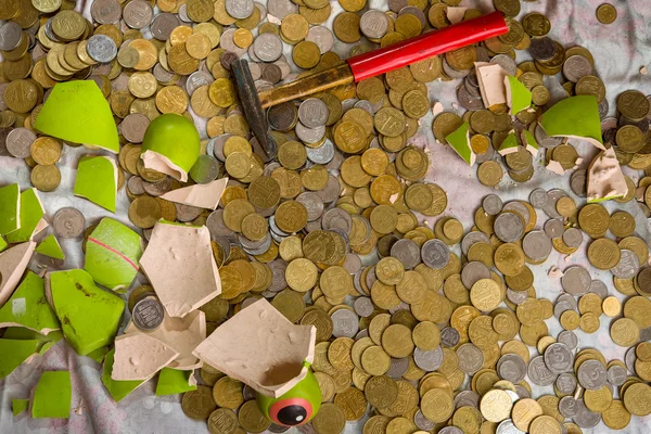 Keramik zerbrochenes Sparschwein. Metallglänzende Münzen. — Stockfoto