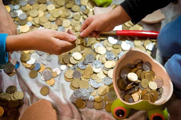 Les enfants croient et considèrent la pièce d'un penny cassé . — Photo