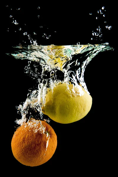 Limone e arancia cadono in acqua — Foto Stock