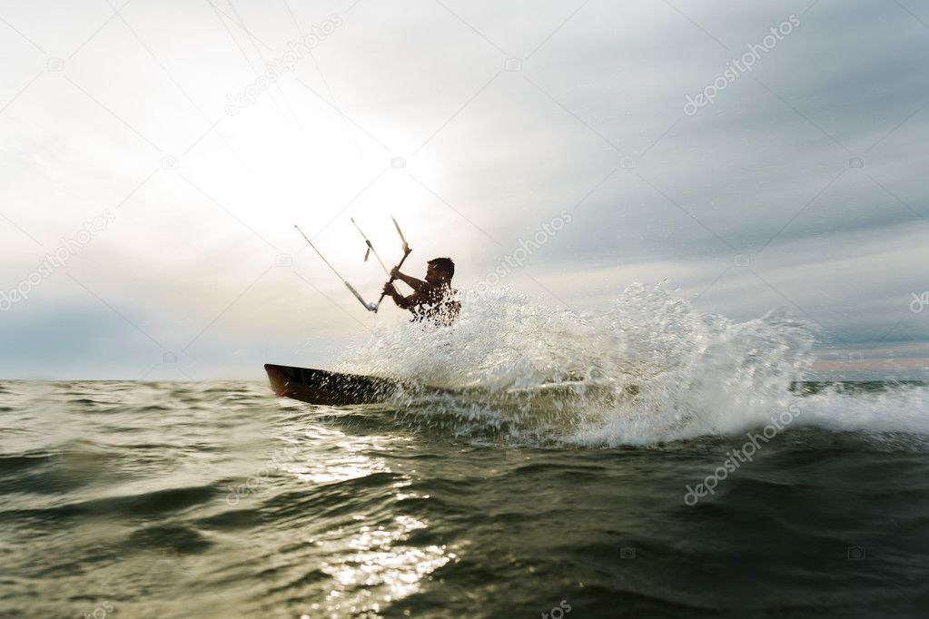 Surfer splashing in front of the sun