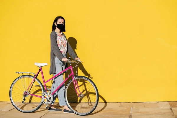 Молодая Девушка Защитной Маске Шагая Перед Красочной Желтой Стеной Розовым — стоковое фото