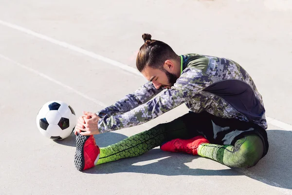 Voetbal Speler Strekkende Benen Zittend Vloer Naast Zijn Voetbal Een — Stockfoto