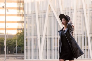 Şapkalı ve trençkotlu güzel Asyalı kadın şehir merkezinde yürüyor, şehir yaşam tarzı konsepti, metin için kopya alanı