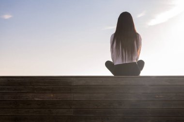 Gün batımında meditasyon yapan uzun saçlı bir kadının arka planı, rahatlama ve zihinsel sağlık kavramı, metin için kopyalama alanı