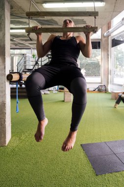 Spor salonunda barfiks çeken genç bir sporcunun dikey fotoğrafı, aktif ve sportif yaşam tarzı konsepti, metin için metin alanı