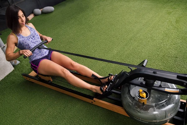 Mulher Esportiva Treinando Sua Força Ginásio Com Uma Máquina Remo — Fotografia de Stock