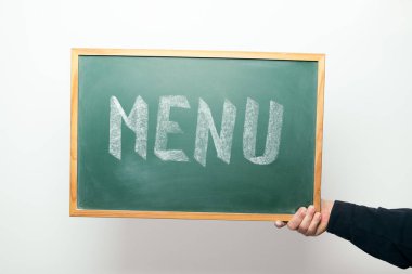 Elinde tebeşirle yazılmış bir karatahta var.