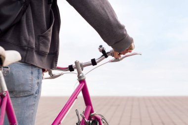 Tanımlanamayan genç adam bisiklet tutuyor, ekolojik ve sürdürülebilir ulaşım kavramı, metin için kopyalama alanı