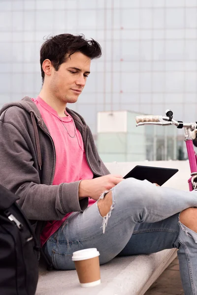 Pionowe Zdjęcie Młodego Studenta Siedzącego Zewnątrz Korzystającego Tabletu Obok Roweru — Zdjęcie stockowe