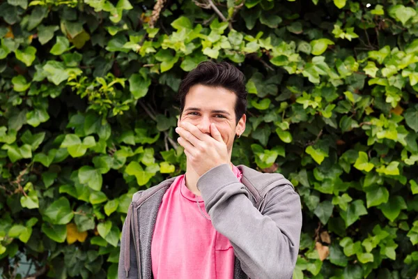 Miły Nastolatek Śmieje Się Zakrywając Usta Jedną Ręką Zielonym Tle — Zdjęcie stockowe