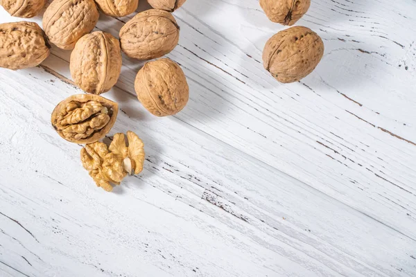 Beyaz ahşap masadaki ceviz çekirdekleri, stok fotoğrafı